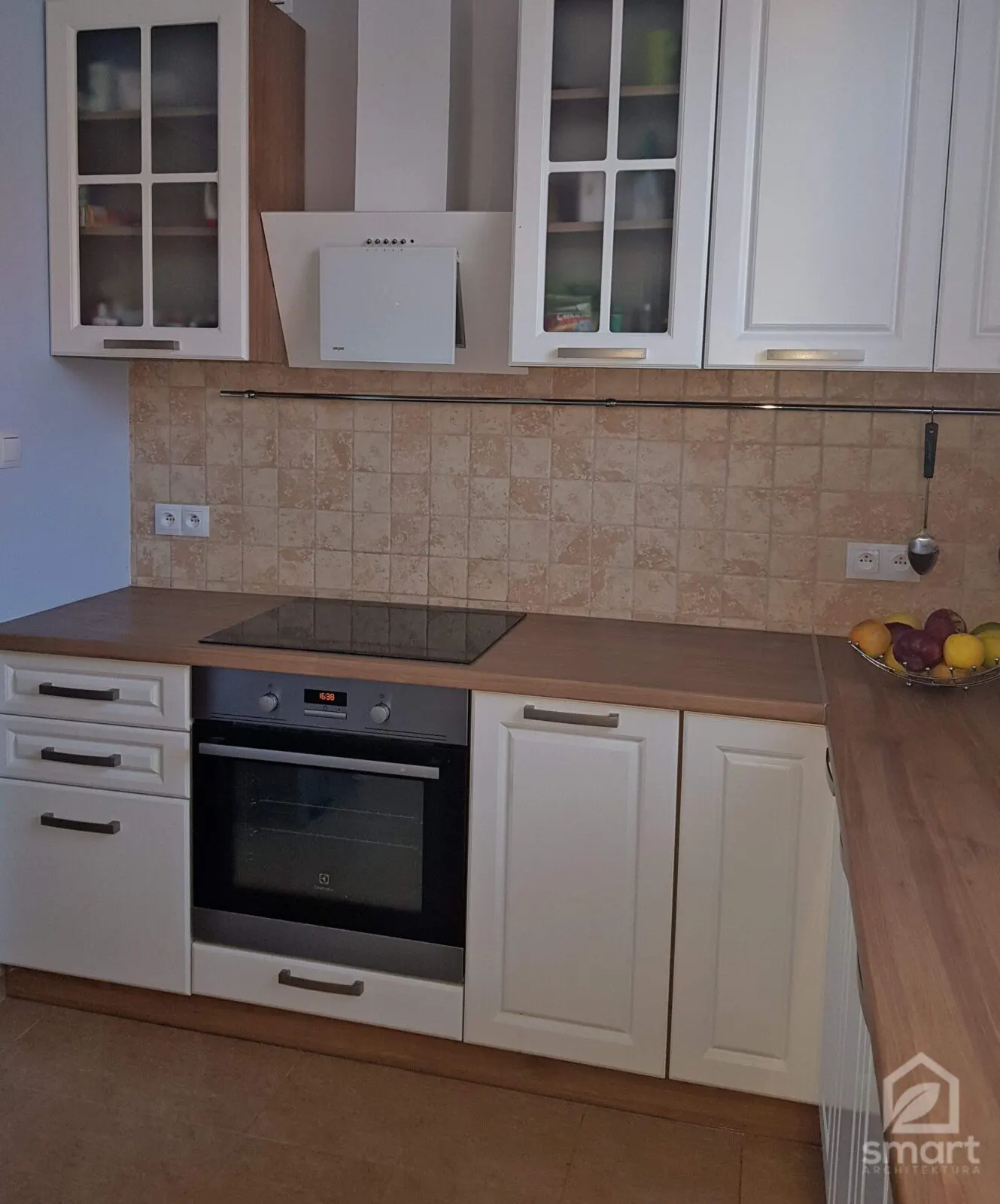 Ciąg kuchenny z piekarnikiem, płytą grzewczą, białym okapem i przeszklonymi szafkami górnymi